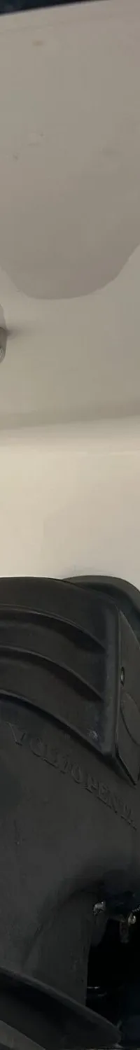 De foto toont het interieur van een kajuit met een U-vormige bank, een houten tafel en een patrijspoort in het plafond.