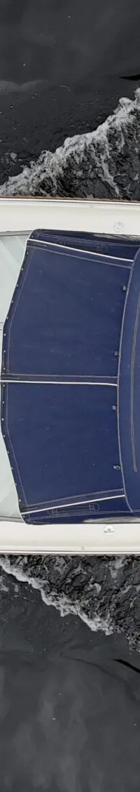 Een witte boot met een blauwe kap vaart op donker water, gezien van bovenaf. — Vedette Vedette 8.80 OK Spiegeldeur