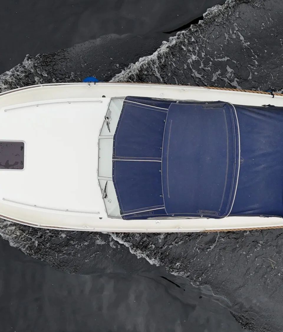 Een witte boot met een blauwe kap vaart op donker water, gezien van bovenaf. — Vedette Vedette 8.80 OK Spiegeldeur