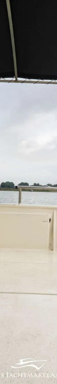Een TFT-kleurenmonitor toont een achteruitkijkbeeld met een Nederlandse vlag en navigatielijnen.