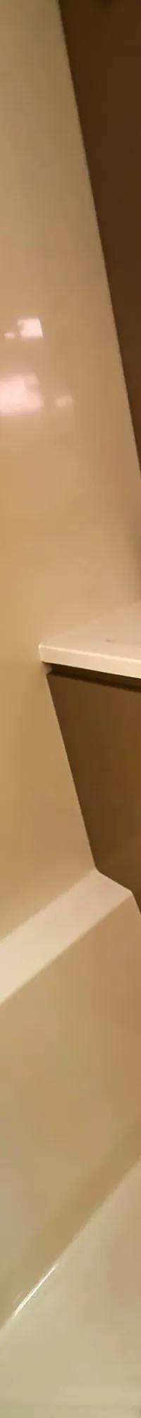 Een witte badkamer met een wastafel, spiegel en een douchegedeelte.