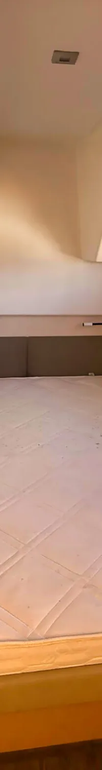 Een kajuit met een tweepersoonsbed, een raam met uitzicht op water en een houten deur met een zilveren handvat.