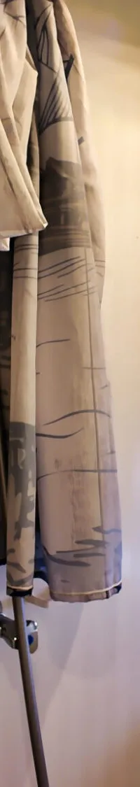 Een badkamer met een douchegordijn met kompasroos, een douchekop en een patrijspoort.