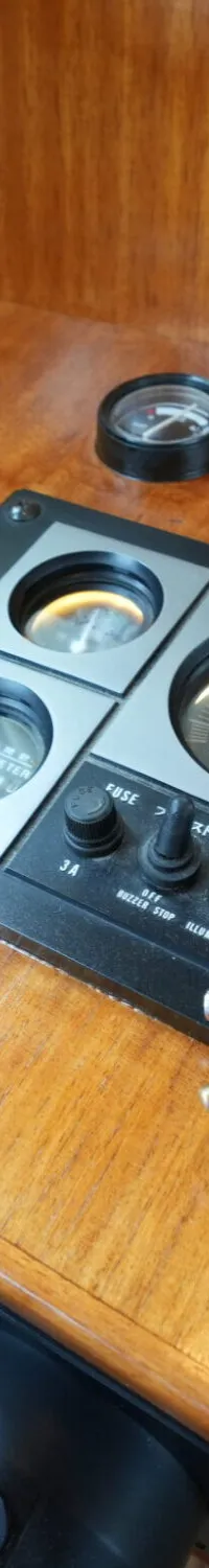 Een houten dashboard met diverse meters, schakelaars en een sleutelbos.