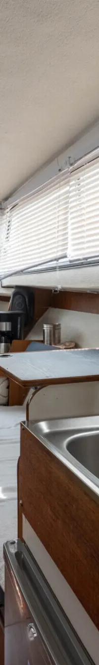 De foto toont het interieur van een boot met een kombuis, slaapplaats en zithoek. — Amerglass Amerglass 32 OK AK