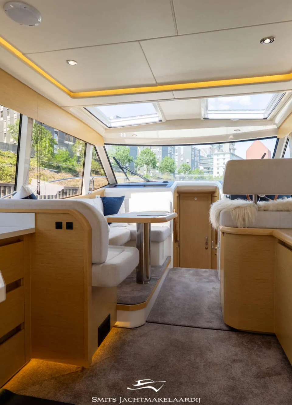 De foto toont het interieur van een boot met een keukenblok, zithoek en stuurstand. — Greenline Greenline 39
