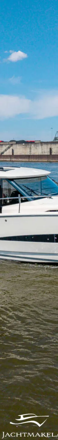 Een witte motorboot met de registratie "DU-K 215" vaart over water met een industriële achtergrond. — Greenline Greenline 39