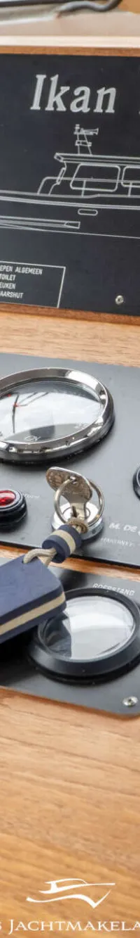 Een houten dashboard met diverse navigatie-instrumenten, schakelaars, meters en een gashendel.
