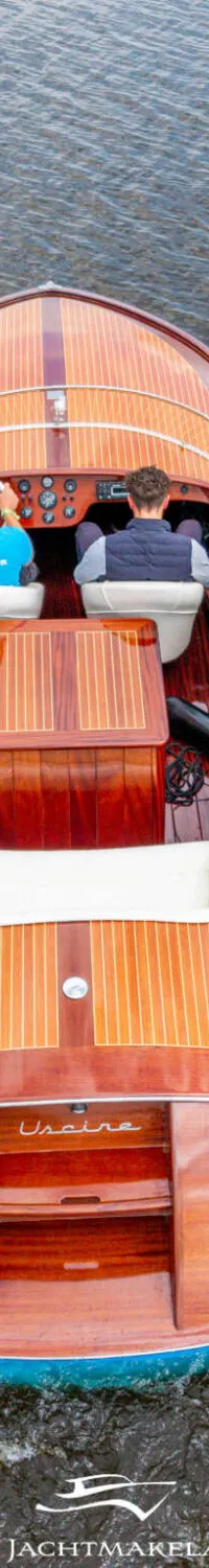 Een houten motorboot met twee opvarenden vaart over water, gezien van bovenaf. — Divank Divank Uscire 635