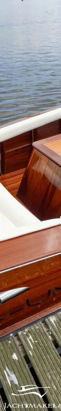 Een houten speedboot met witte bekleding en een houten dek ligt afgemeerd aan een houten steiger. — Divank Divank Uscire 635