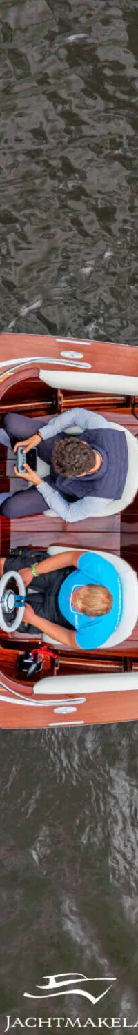 Een houten boot met twee personen aan boord vaart op het water, gezien van bovenaf. — Divank Divank Uscire 635