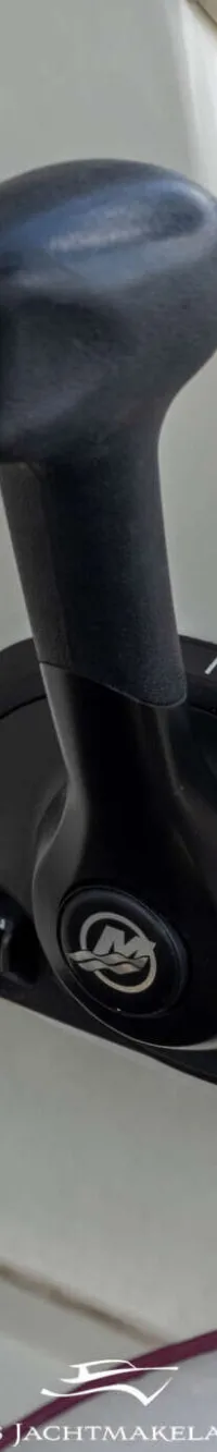 Een close-up van een zwarte gashendel met een dodemanskoord, sleutels en een digitaal display op een wit paneel.