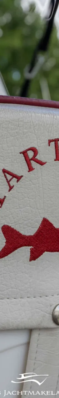 Een witte bootstoel met rode bies en een rood geborduurd logo van een haai en de tekst "SMARTLINER".