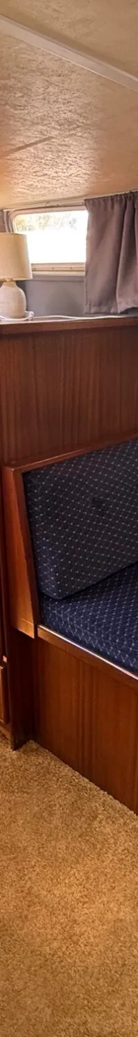 De foto toont een interieur van een boot met een kombuis, een eethoek en een tapijt op de vloer.