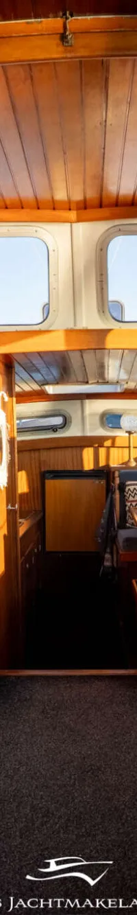 Een witte boot met een bruin houten paneel waarop de naam "François" in witte letters staat, met daarboven een raam.