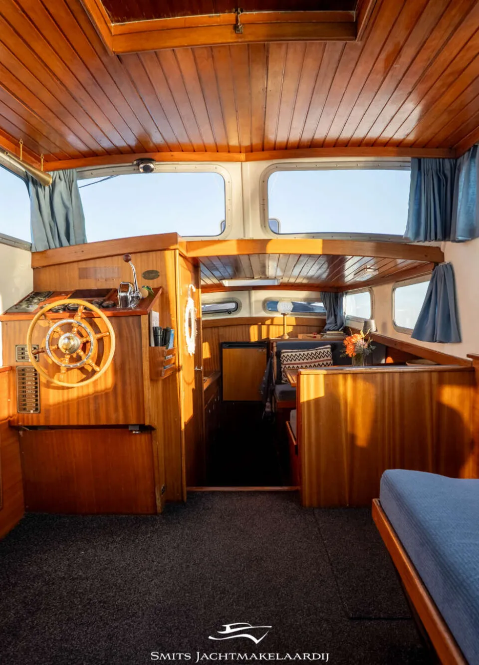 Een witte boot met een bruin houten paneel waarop de naam "François" in witte letters staat, met daarboven een raam.