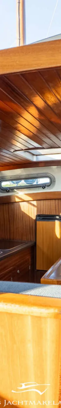 Een close-up van een blauwe scheepsmotor met chromen onderdelen en diverse leidingen en kabels.