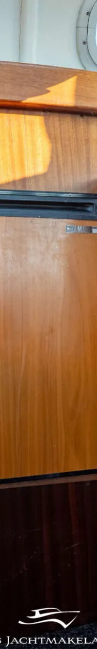 Een interieur van een boot met houten wanden, een koelkast, een bank met kussens en ramen. — Dompvlet Dompvlet 9.00 AK