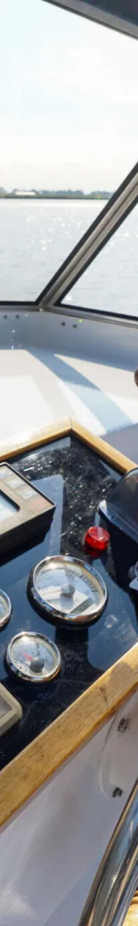 De foto toont het stuurwiel en het dashboard van een boot, met uitzicht op water en de horizon. — Valkkruiser 10.50 Ak Cabrio