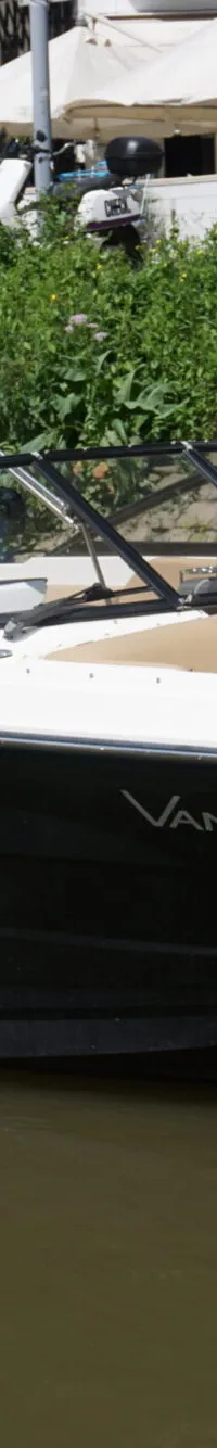 Een zwart-witte speedboot met de naam 'VANTASTIC' en registratienummer '3-YB-226' vaart op het water met één persoon aan…