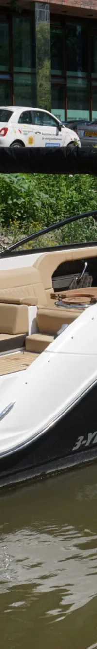 Een motorboot met zwarte romp en witte opbouw, beige bekleding en registratienummer 3-YB-226 vaart op het water.