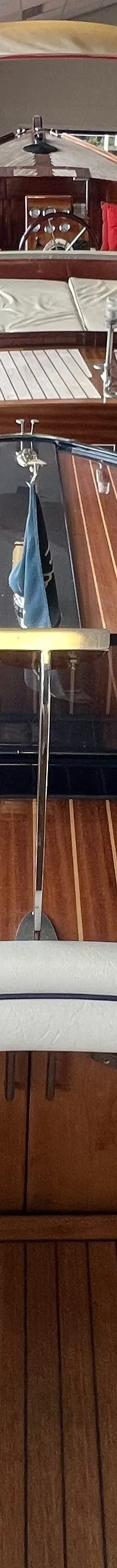 Een houten boot met een wit interieur en een houten stuurwiel, gezien vanuit de cockpit. — Frauscher 757 St. Tropez