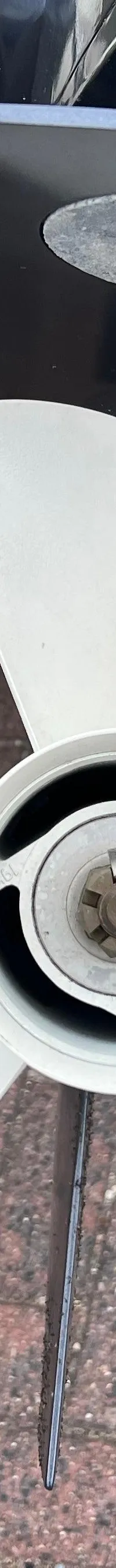 Een witte driebladige schroef van een buitenboordmotor, een zinkanode en een zwemtrap zijn zichtbaar.