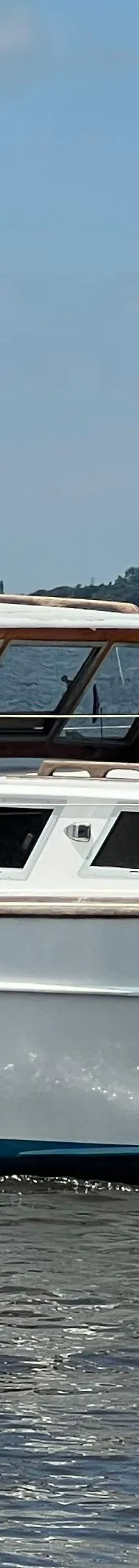 Een witte motorboot met de naam "Jenneke" vaart op een waterweg met bomen op de achtergrond. — Kruiser Polyflash 950