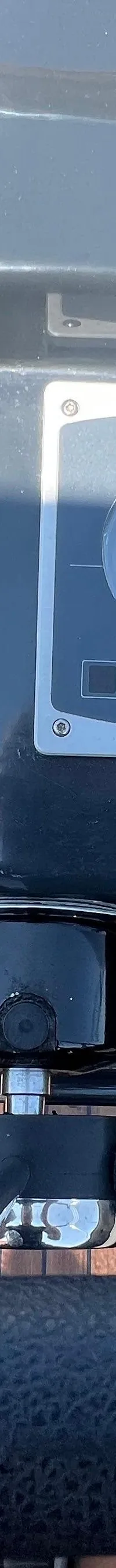 Een stuurwiel, dashboard met meters en een gashendel zijn zichtbaar in een boot met een houten dek. — Asloep 770